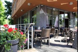 Un patio al aire libre con mesas, sillas y flores. en Apartament 303 Planeta, en Mielno