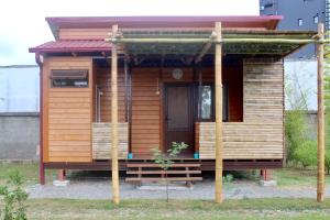 a small wooden cabin with a porch and a door at Apartments and cottages in Batumi in Batumi