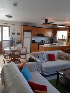 a living room with couches and a table and a kitchen at Zena Holiday Villa in Pissouri