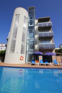 a hotel with a swimming pool in front of a building at Hotel TossaMar in Tossa de Mar