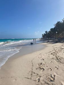 una playa con huellas en la arena y el océano en Casa Ingrid en San Andrés