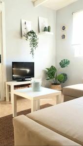 a living room with a white table and a tv at Atico en el corazón de Santa Cruz/ Cozy Penthouse in Santa Cruz de Tenerife