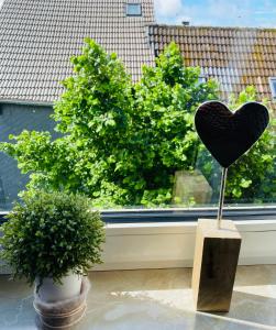 un corazón negro en un puesto frente a una ventana en Ferienwohnungen Naturzeit en Willingen