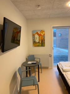 Den Gode Søvn في Øster Hurup: غرفة مع طاولة وكراسي وسرير