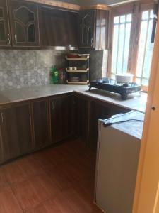 a kitchen with wooden cabinets and a counter top at ViveGee Cottage Khanipur Ayubia in Ayubia +46 photos