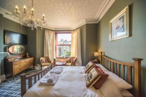 a bedroom with a bed and a chandelier at Compton Guest House in Buxton