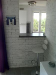 a kitchen with a counter and a window and a stool at LE BELVEDERE 1- Front de Mer - Plage Argelès in Argelès-sur-Mer