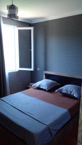 a bedroom with a large bed with a window at Pirosmani 66 in Sighnaghi