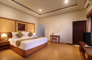 Un dormitorio con una cama grande y un televisor. en Sudha Villa Bali B, en Seminyak 43 fotos más