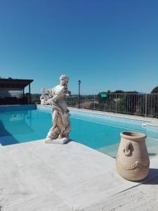 una statua di una donna in piedi accanto a una piscina di Camere Il Meoccio a Manciano