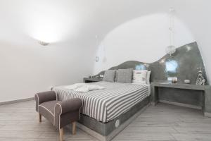 une chambre avec un lit et une chaise dans l'établissement Fira-Cave-Sleeps 13-Parking-Pool-Pet Friendly, à Fira 29 autres photos