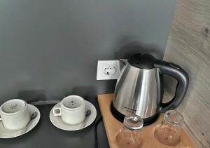 a tea kettle and two cups on a table at Beypark Hotel in Istanbul