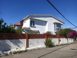 a white house with a fence in front of it at Chalet independiente zona Coruxo in Oya