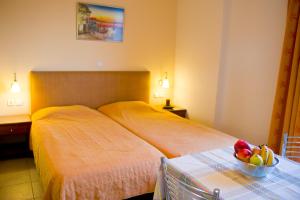 a bedroom with two beds and a bowl of fruit on a table at Villa Dora in Tolo