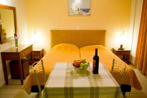 a table with a bottle of wine and a bowl of fruit at Villa Dora in Tolo