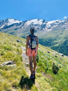 Una mujer con una mochila caminando por una montaña en Alois Ferienglück, en Nauders