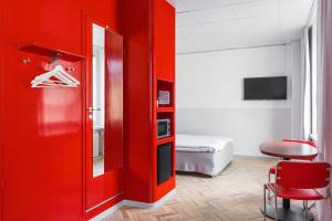 タンペレにあるオメナ ホテル タンペレの赤いドアとベッドルームが備わる赤い部屋