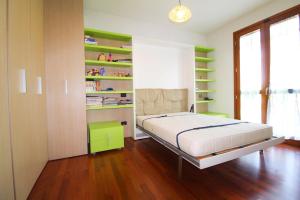 a bedroom with a bed with green shelves at Archimede in Lido di Jesolo