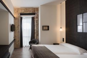 een hotelkamer met een bed en een stoel bij Hotel Sant Agustí in Barcelona