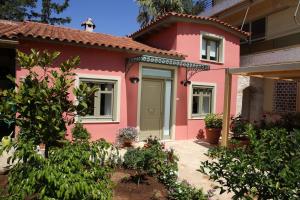 una casa rosa con una puerta verde en For4 Seasons Home 2 - by Avelink, en Spáta