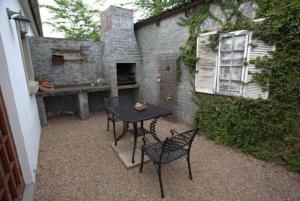 een patio met een tafel en stoelen voor een gebouw bij Apple Cottages in George