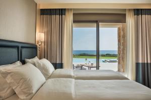 a bedroom with a bed and a view of the ocean at Electra Kefalonia Hotel & Spa in Svoronata