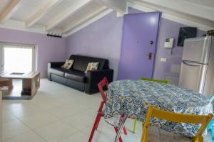a living room with a table and a couch at Apartment Viole, cozy attic set in the old town next to the lake in Arona