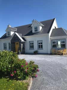 una gran casa blanca con una entrada de grava en Knockaguilla House Bed & Breakfast, en Doolin