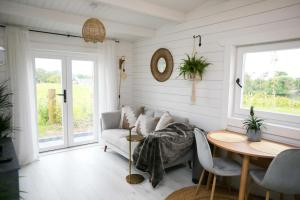 een woonkamer met een bank en een tafel bij The Paddocks Cabin - Stylish, Cozy & Private in Killarney