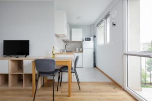 een keuken met een tafel en stoelen en een televisie bij Apartments City Center Powiśle in Warschau