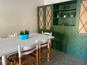 Malón的住宿－Casa Rural Hestia，一间设有白色桌子和绿色橱柜的用餐室