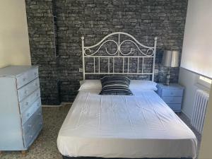 1 dormitorio con cama y pared de ladrillo en Casa Rural Hestia, en Malón