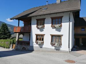 a white house with windows and flower boxes at Ferienwohnung Holzer in Sankt Michael im Lungau