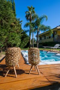 2 sedie sedute su una terrazza accanto alla piscina di Musae Apartments ad Agropoli