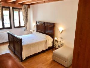 Un dormitorio con una cama grande y una silla. en Turazza Apartments, en Malcesine