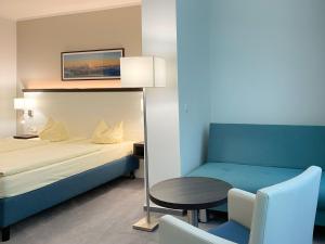 1 dormitorio con 1 cama, 1 mesa y 1 silla en Strandhotel Graal-Müritz, en Graal-Müritz