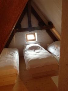 Schlafzimmer im Dachgeschoss mit 2 Betten und einem Fenster in der Unterkunft Le Gîte du Donon in Grandfontaine
