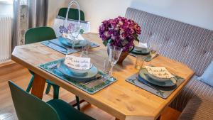 a wooden table with plates and bowls and flowers on it at Auszeit Aussee in Bad Aussee
