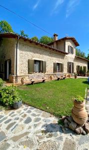 ein großes Steinhaus mit einem Hof mit einem Hof in der Unterkunft Spacious House in Ogassa with Terrace and BBQ in Ogassa + 36 Fotos