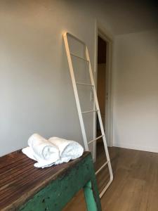 eine Leiter, die an einer Wand lehnt, mit Kissen auf einem Tisch in der Unterkunft duunn2 in Koksijde + 26 Fotos
