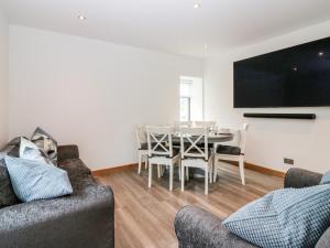 a living room with a table and a tv at Fisherman's Cottage in Fraserburgh