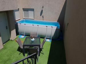 a swimming pool in a backyard with a table and chairs at בית בלב מדבר little house in the desert in Yeroẖam