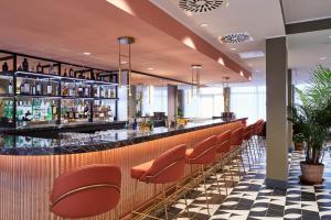 ローマにあるHotel Villa Pamphili Romaの赤い椅子が備わるホテル内のバー