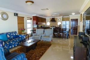 a living room with blue couches and a dining room at Boathouse Ballito in Ballito