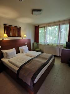 een slaapkamer met een groot bed in een kamer bij Hotel Villa Pax in Balatonalmádi