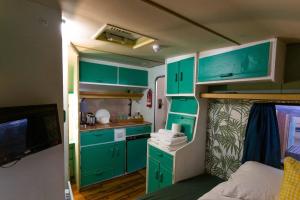 a small kitchen with green cabinets in an rv at Towed Town Camping in Bristol