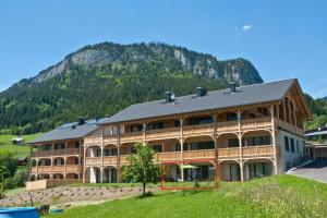 een groot gebouw met een berg op de achtergrond bij Appartement Grimminggarten in Tauplitz