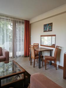 ein Wohnzimmer mit Tisch und Stühlen in der Unterkunft Hotel Villa Pax in Balatonalmádi