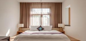 una camera da letto con un letto con due lampade e una finestra di The One Nanyuan a Xinpu