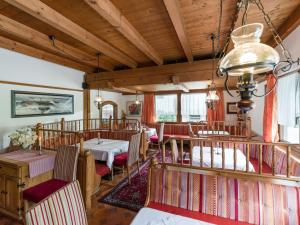 ein Wohnzimmer mit Holzdecken sowie Tischen und Stühlen in der Unterkunft Hotel Restaurant Sidan in Schwendau